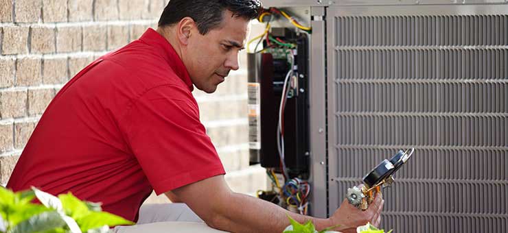 HVAC technician doing routine air conditioner maintenance