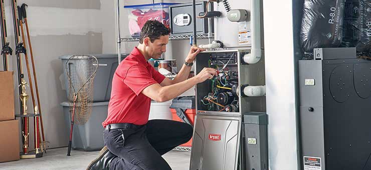 HVAC technician doing routine furnace maintenance