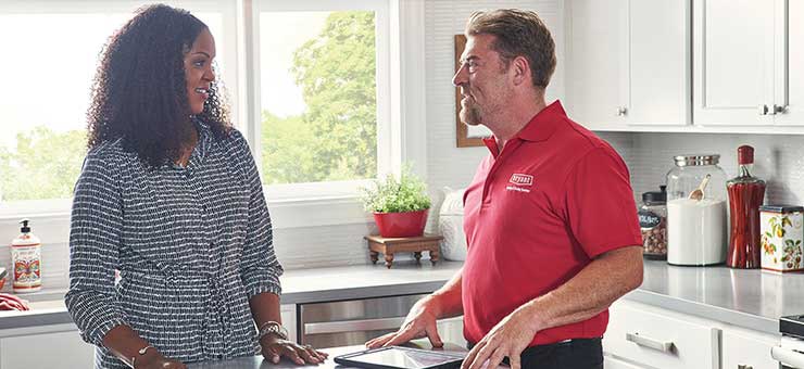Salesperson discussing various indoor air quality products and services with homeowner